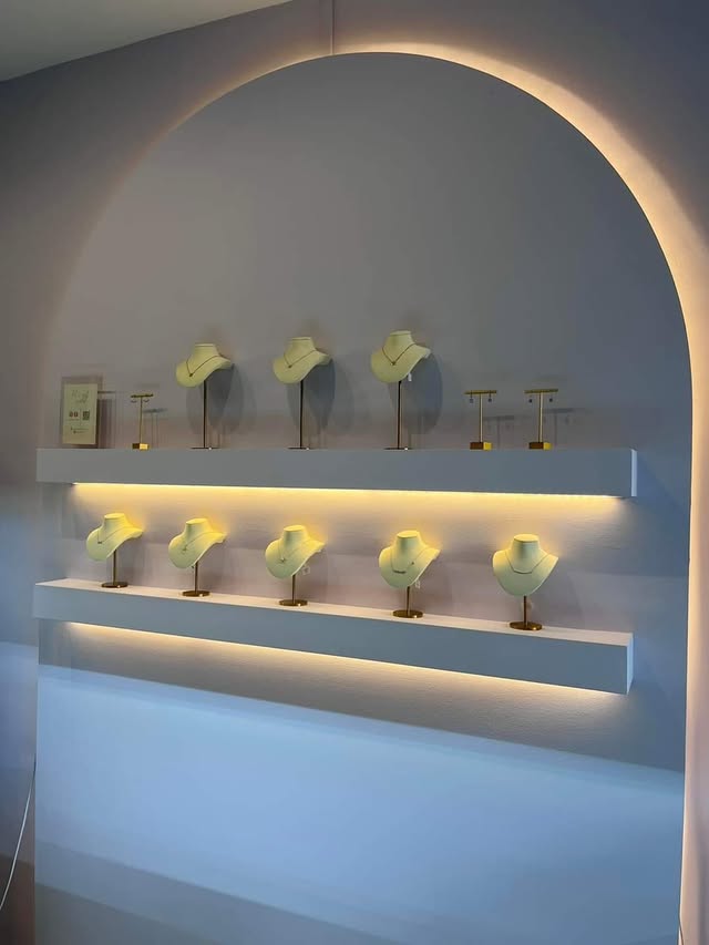 Retail display niche with arched cove lighting and floating shelves